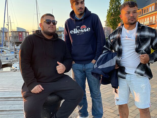 Drei junge Männer am Yachthafen von Sonwik