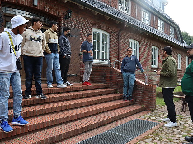 Junge Menschen auf einer Treppe vor dem Haus